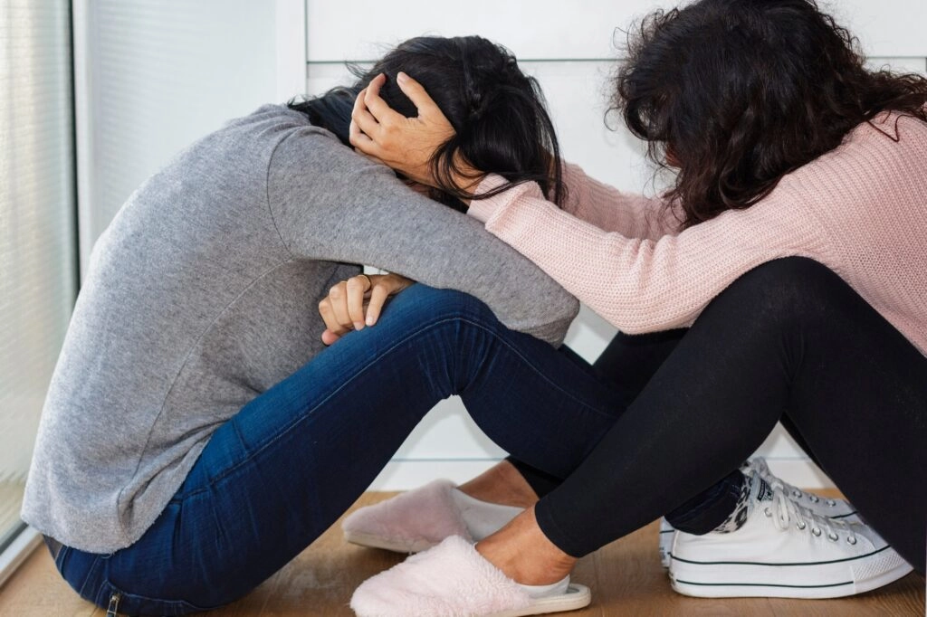 Woman helping her depressed friend holding her head